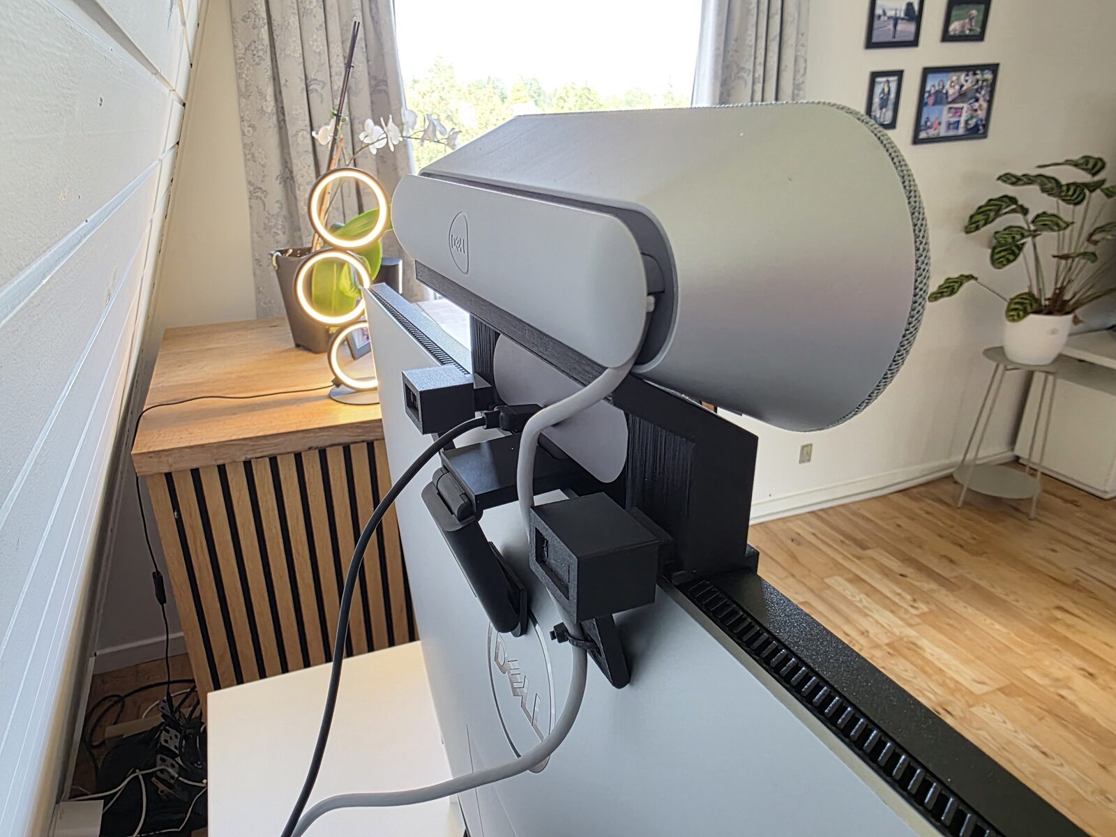 The speaker perch in place — the soundbar bridged over the webcam, cables routed down